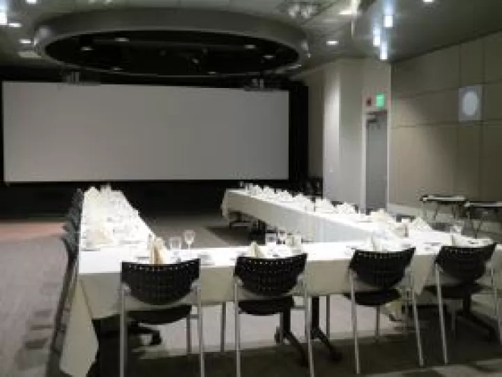 Tables arranged with a table cloth and place settings.