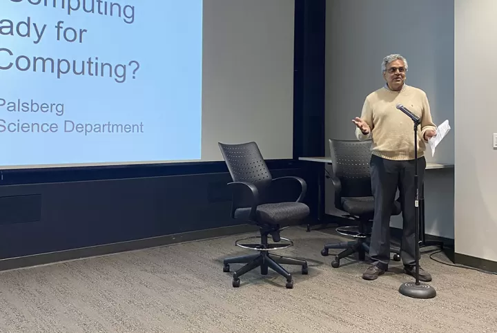 Man standing at a microphone before a lecture