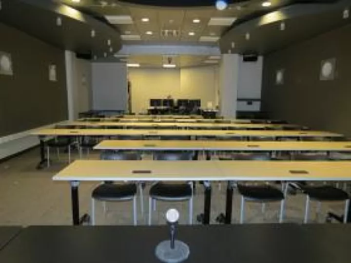 Chairs and tables arranged to face a podium, from the view of the person at the podium.