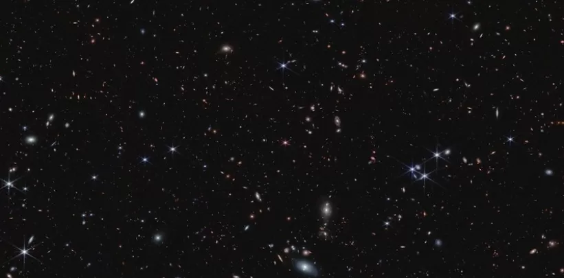  More than 20,000 tiny galaxies appear across the black background of space.