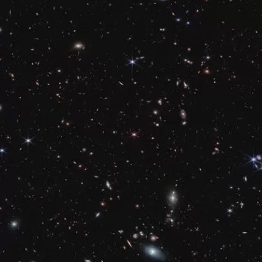  More than 20,000 tiny galaxies appear across the black background of space.